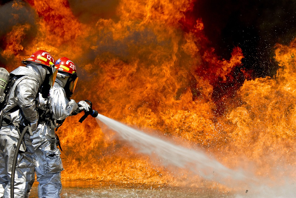 Dehumanization: Can We Rationally Deny The Unborn Personhood? Two firefighters directing a hose toward a large fire.