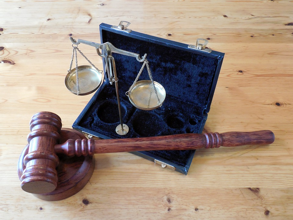 Dehumanization: Can We Rationally Deny The Unborn Personhood? A wooden gavel and balance scales in an open case.